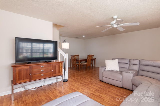 10548 English Setter Way, Charlotte, NC 28269 - living room featuring light wood-style floors, ceiling fan, a textured ceiling, and baseboards
