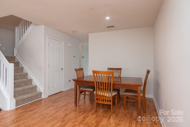 10548 English Setter Way, Charlotte, NC 28269 - dining space with a textured ceiling, light wood-type flooring, stairway, baseboards, and recessed lighting