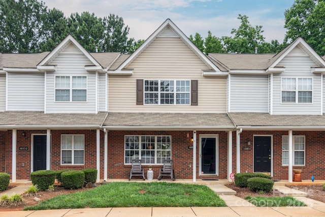10548 English Setter Way, Charlotte, NC 28269 - view of property featuring brick siding, a porch, and roof with shingles