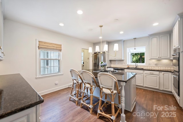 7022 Lancer Dr, Charlotte, NC 28226 - kitchen with appliances with stainless steel finishes, a breakfast bar, tasteful backsplash, dark wood-type flooring, and recessed lighting