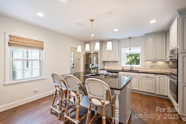 7022 Lancer Dr, Charlotte, NC 28226 - kitchen with stainless steel appliances, tasteful backsplash, a center island, a kitchen breakfast bar, and dark wood-type flooring