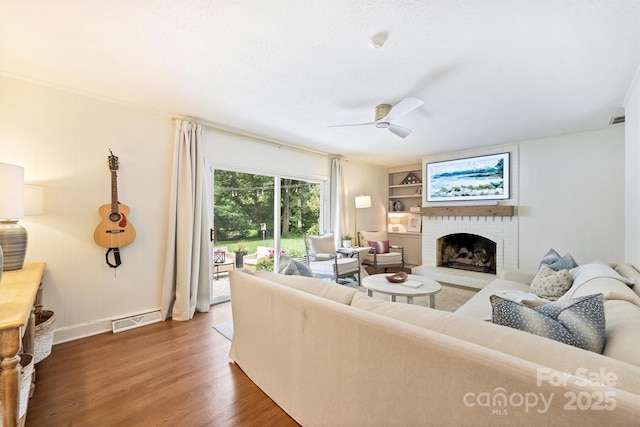 7022 Lancer Dr, Charlotte, NC 28226 - living room with a fireplace, ceiling fan, wood finished floors, and built in shelves