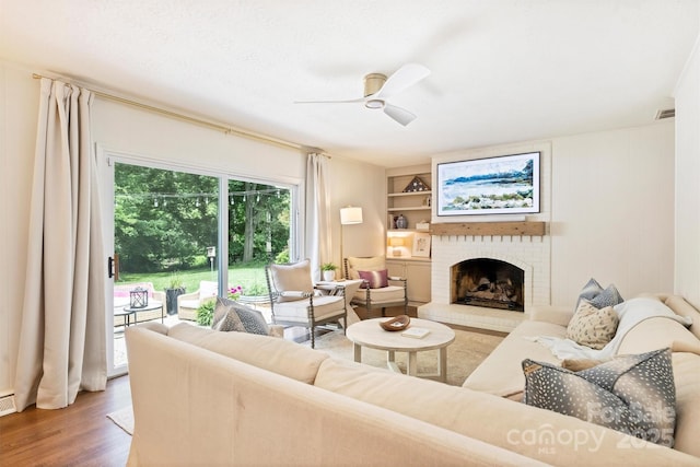 7022 Lancer Dr, Charlotte, NC 28226 - living area featuring wood finished floors, a fireplace, and a ceiling fan