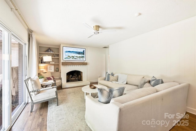 7022 Lancer Dr, Charlotte, NC 28226 - living area featuring wood finished floors, a ceiling fan, a brick fireplace, and built in features