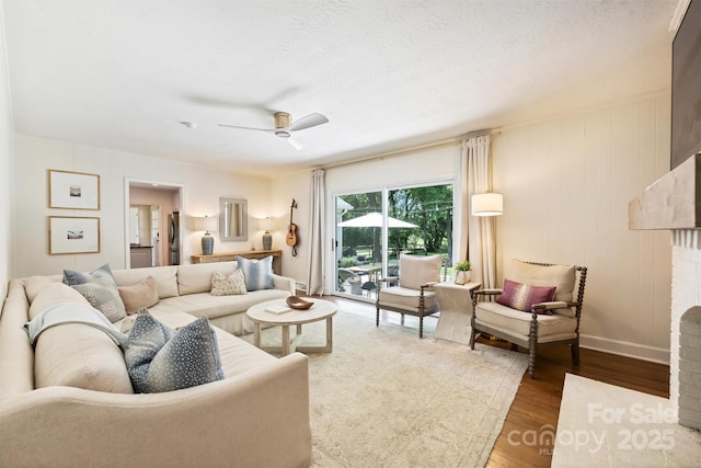 7022 Lancer Dr, Charlotte, NC 28226 - living room with wood finished floors, a fireplace, a ceiling fan, and a textured ceiling