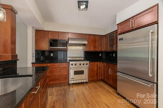74 Eastmoor Dr, Asheville, NC 28805 - kitchen with high quality appliances, wall chimney exhaust hood, wood finished floors, backsplash, and dark stone countertops