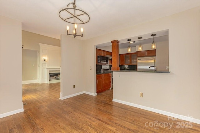 74 Eastmoor Dr, Asheville, NC 28805 - kitchen with stainless steel built in fridge, dark countertops, black microwave, wood finished floors, and a chandelier