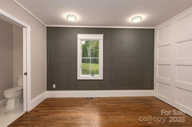 74 Eastmoor Dr, Asheville, NC 28805 - empty room with crown molding, baseboards, dark wood finished floors, and wallpapered walls