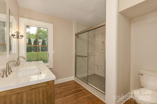 74 Eastmoor Dr, Asheville, NC 28805 - full bathroom featuring toilet, a marble finish shower, double vanity, wood finished floors, and baseboards