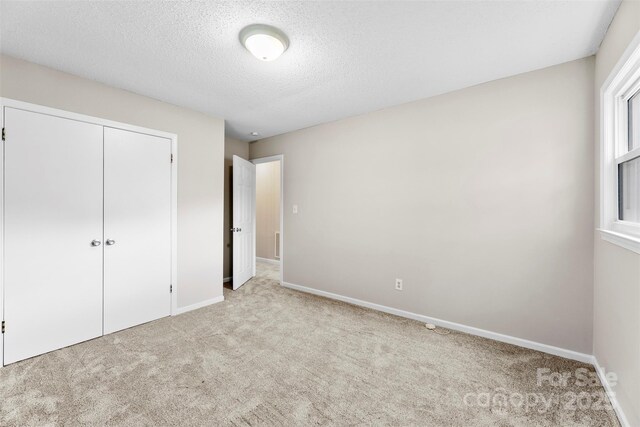 1606 Northwoods Dr, Kings Mountain, NC 28086 - unfurnished bedroom featuring carpet floors, baseboards, a closet, and a textured ceiling