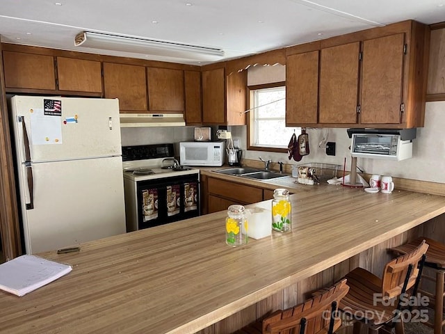 239 Laurel Dr, Whittier, NC 28789 - kitchen featuring white appliances, a sink, under cabinet range hood, and brown cabinets