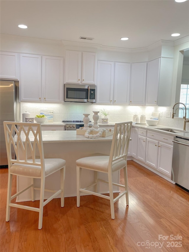 1006 Phar Lap Dr, Indian Trail, NC 28079 - kitchen featuring stainless steel appliances, a sink, white cabinetry, backsplash, and light countertops