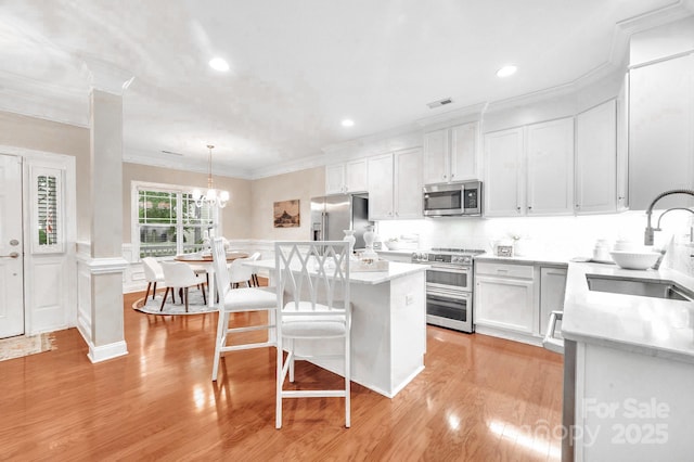 1006 Phar Lap Dr, Indian Trail, NC 28079 - kitchen with appliances with stainless steel finishes, ornamental molding, a sink, a center island, and a breakfast bar