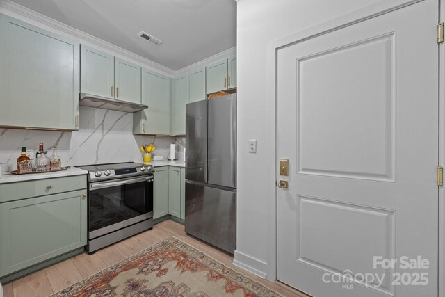 630 Calvert St Unit 111, Charlotte, NC 28208 - kitchen with stainless steel appliances, under cabinet range hood, light wood-type flooring, green cabinetry, and light countertops