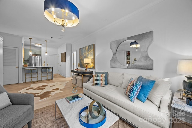 630 Calvert St Unit 111, Charlotte, NC 28208 - living room featuring light wood-style flooring, a chandelier, and ornamental molding