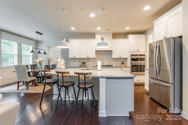 5130 Watersail Way, Clover, SC 29710 - kitchen featuring appliances with stainless steel finishes, white cabinets, tasteful backsplash, a center island with sink, and recessed lighting