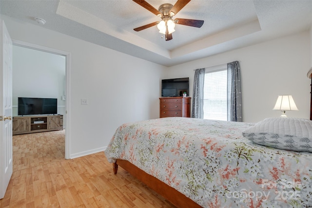 110 Eighth St, York, SC 29745 - bedroom with a tray ceiling, light wood-style floors, baseboards, and a ceiling fan