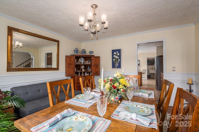 112 Ocean Dr, Shelby, NC 28152 - dining area with a chandelier, wood finished floors, wainscoting, a textured ceiling, and crown molding
