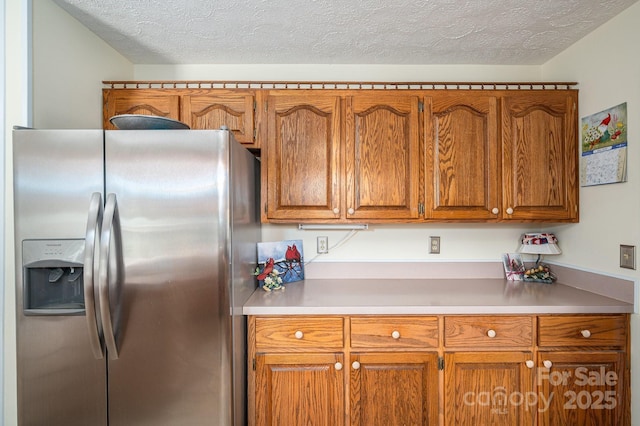112 Ocean Dr, Shelby, NC 28152 - kitchen featuring stainless steel refrigerator with ice dispenser, brown cabinetry, a textured ceiling, and light countertops