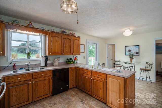 112 Ocean Dr, Shelby, NC 28152 - kitchen featuring black dishwasher, a sink, a peninsula, brown cabinetry, and a textured ceiling