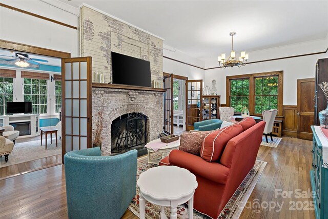 147 Preservation Way, Waynesville, NC 28786 - living room with a fireplace, wood-type flooring, a chandelier, plenty of natural light, and wainscoting