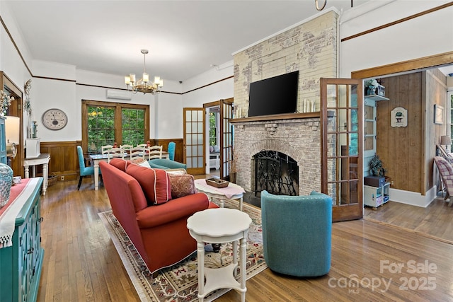 147 Preservation Way, Waynesville, NC 28786 - living room with a chandelier, hardwood / wood-style flooring, wainscoting, a fireplace, and crown molding