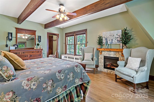 147 Preservation Way, Waynesville, NC 28786 - bedroom with wood finished floors, beamed ceiling, radiator, a fireplace, and a ceiling fan