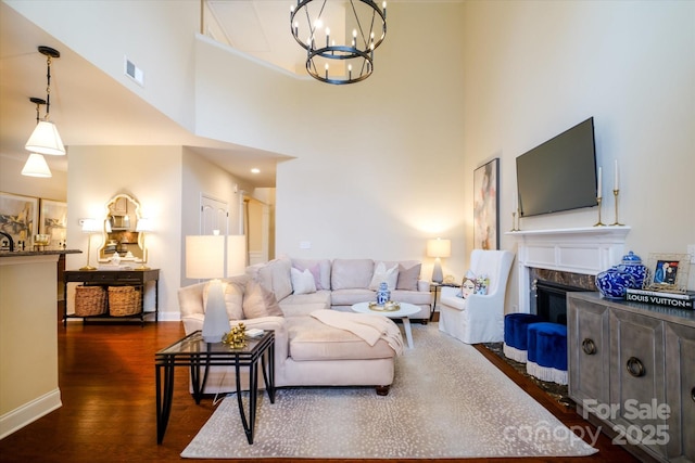 4323 Bright Rd, Charlotte, NC 28214 - living area featuring a chandelier, a high ceiling, dark wood-type flooring, a premium fireplace, and baseboards