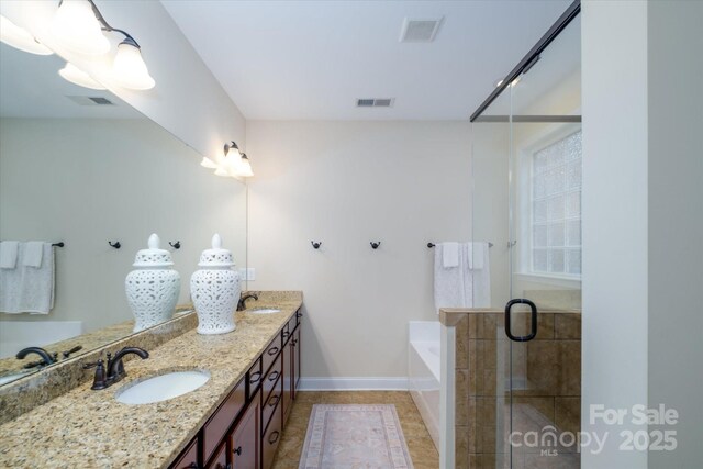 4323 Bright Rd, Charlotte, NC 28214 - bathroom with a garden tub, double vanity, a stall shower, baseboards, and tile patterned flooring