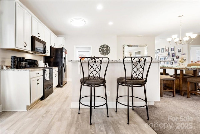 620 River Birch Dr, Salisbury, NC 28146 - kitchen with black appliances, a kitchen bar, a chandelier, white cabinetry, and light stone countertops