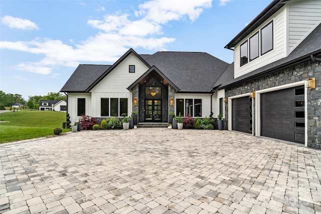 38 Thistle Ln, Fletcher, NC 28732 - view of front of home with stone siding, decorative driveway, a front yard, a garage, and board and batten siding