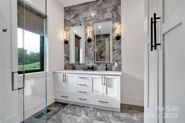 38 Thistle Ln, Fletcher, NC 28732 - bathroom with double vanity, marble finish floors, decorative backsplash, baseboards, and a shower with shower door