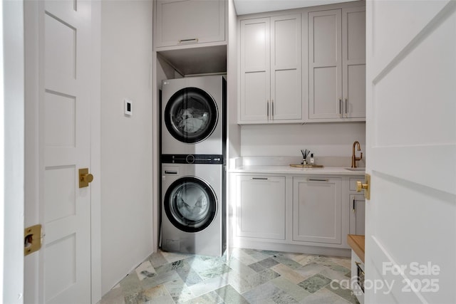 38 Thistle Ln, Fletcher, NC 28732 - laundry area featuring stacked washer / drying machine, cabinet space, and light stone finish floors