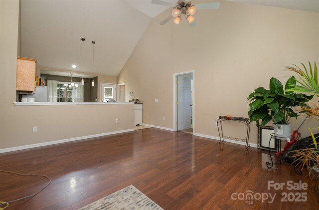 159 Pitts School Rd NW, Concord, NC 28027 - unfurnished living room with high vaulted ceiling, wood finished floors, ceiling fan, baseboards, and a chandelier