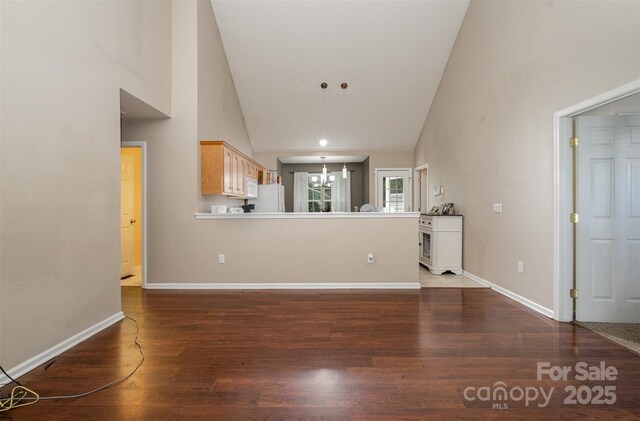 159 Pitts School Rd NW, Concord, NC 28027 - unfurnished living room with a chandelier, high vaulted ceiling, wood finished floors, and baseboards