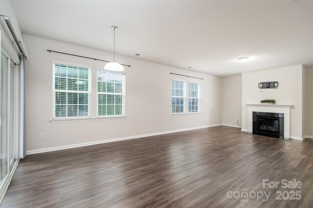 150 W Morehouse Ave, Mooresville, NC 28117 - unfurnished living room with dark wood-style floors, a glass covered fireplace, and baseboards