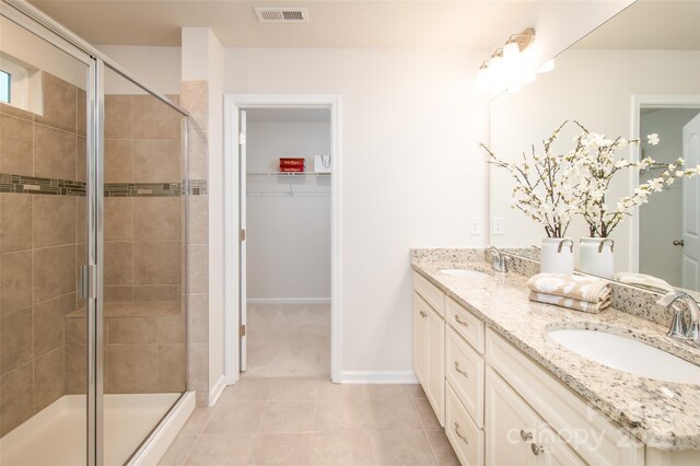 150 W Morehouse Ave, Mooresville, NC 28117 - full bathroom with double vanity, a shower stall, a spacious closet, baseboards, and tile patterned floors