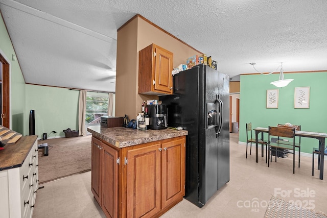 112 Cordella Rd, Candler, NC 28715 - kitchen featuring dark countertops, black fridge, brown cabinetry, a textured ceiling, and hanging light fixtures