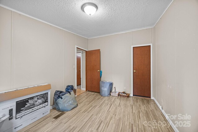 112 Cordella Rd, Candler, NC 28715 - unfurnished living room with a textured ceiling, wood finished floors, and ornamental molding