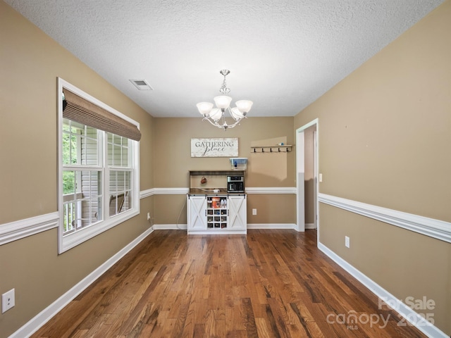 5369 Concord Rd, York, SC 29745 - unfurnished dining area with a chandelier, wood finished floors, baseboards, and a textured ceiling