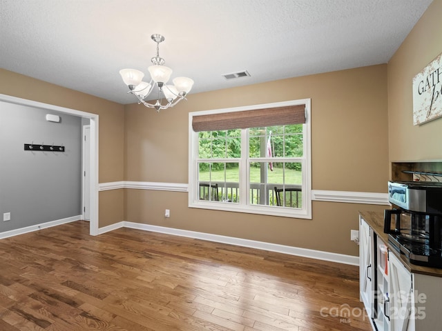 5369 Concord Rd, York, SC 29745 - unfurnished dining area with a chandelier, wood finished floors, baseboards, and a textured ceiling