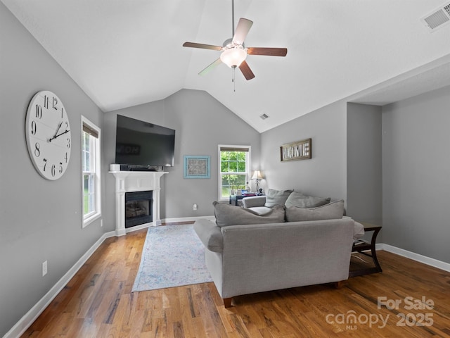 5369 Concord Rd, York, SC 29745 - living room featuring a ceiling fan, vaulted ceiling, wood finished floors, a glass covered fireplace, and baseboards