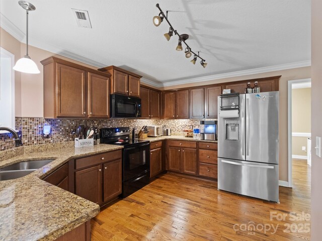 5369 Concord Rd, York, SC 29745 - kitchen with black appliances, a sink, crown molding, light stone countertops, and light wood finished floors