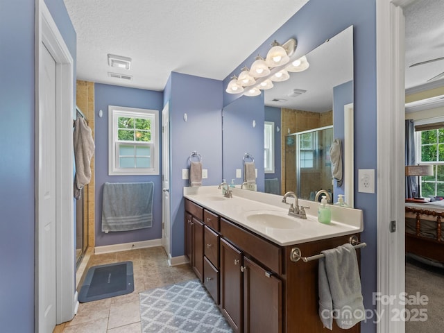 5369 Concord Rd, York, SC 29745 - bathroom featuring a stall shower, double vanity, a textured ceiling, baseboards, and tile patterned flooring