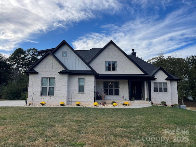 1427 Kinks Ln Unit 47, Maiden, NC 28650 - view of front of property featuring board and batten siding, a front lawn, brick siding, a chimney, and a porch