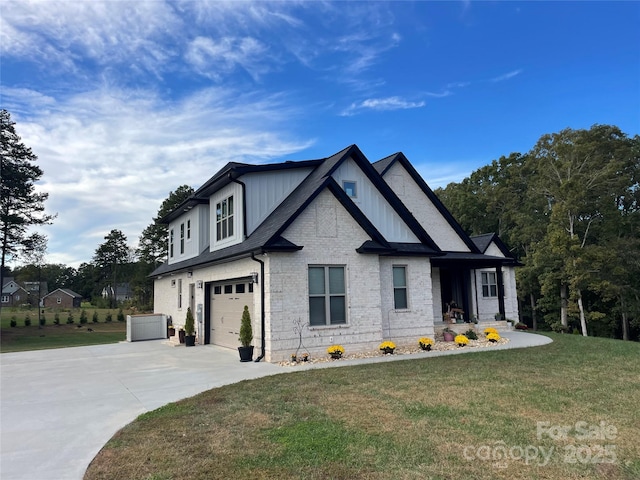 1427 Kinks Ln Unit 47, Maiden, NC 28650 - view of front of home with concrete driveway, a garage, a front yard, board and batten siding, and brick siding
