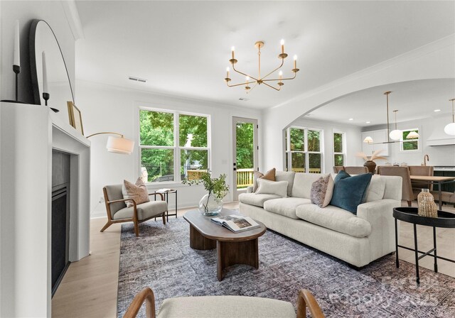 2033 Camp Greene St, Charlotte, NC 28208 - living area featuring ornamental molding, plenty of natural light, wood finished floors, a chandelier, and arched walkways