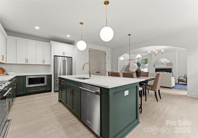 2033 Camp Greene St, Charlotte, NC 28208 - kitchen featuring green cabinets, a sink, appliances with stainless steel finishes, white cabinetry, and light wood-style floors