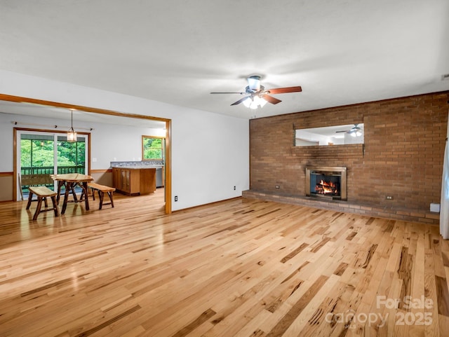 989 Mine Gap Rd, Zirconia, NC 28790 - living room featuring wood finished floors, a ceiling fan, a fireplace, and brick wall