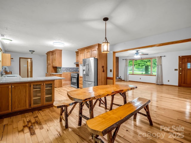 989 Mine Gap Rd, Zirconia, NC 28790 - kitchen with appliances with stainless steel finishes, a sink, light wood finished floors, and tasteful backsplash